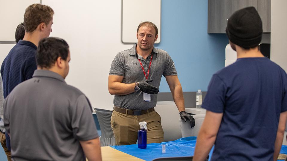 An instructor talks to a group of students.