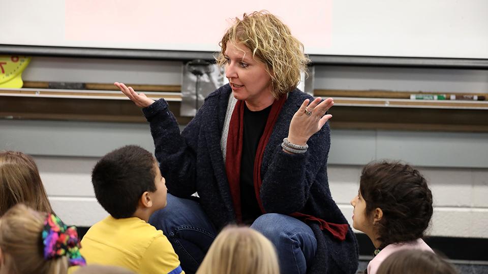 A teacher interacts with a class of young children.