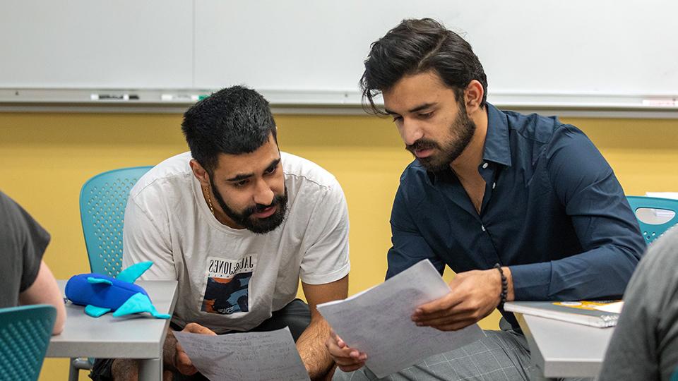 Two students working through a math problem.