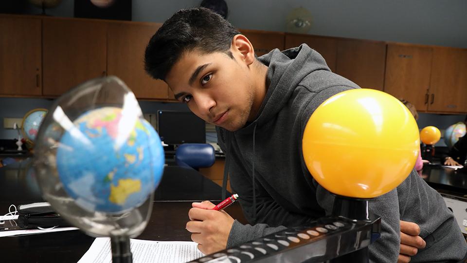 Student looking at a model of planets