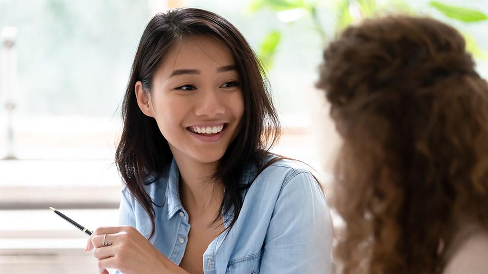 Two students smile while conversing.