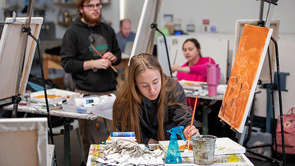 Student painting in a Fine Arts & Design studio