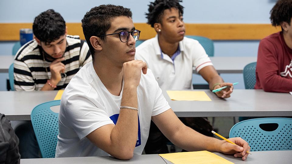 Students at classroom tables listening to a lecture