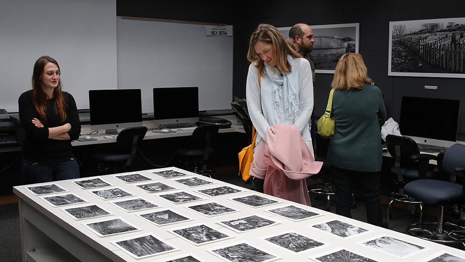 Person examining and exhibit of student photography work