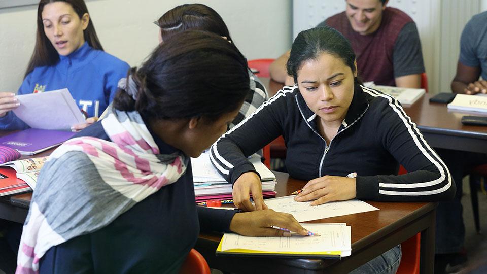 ESL students working with an instructor in a classroom