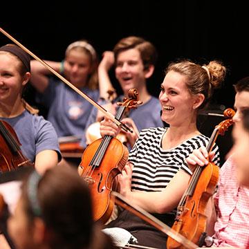 Smiling, seated violinists